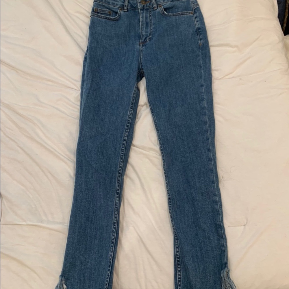 Subdued blue skinny jeans with fray/fringe details